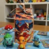 Caja decorada Pokémon Charizard, diseño rectangular con tapa, tonos rojo, naranja y negro.